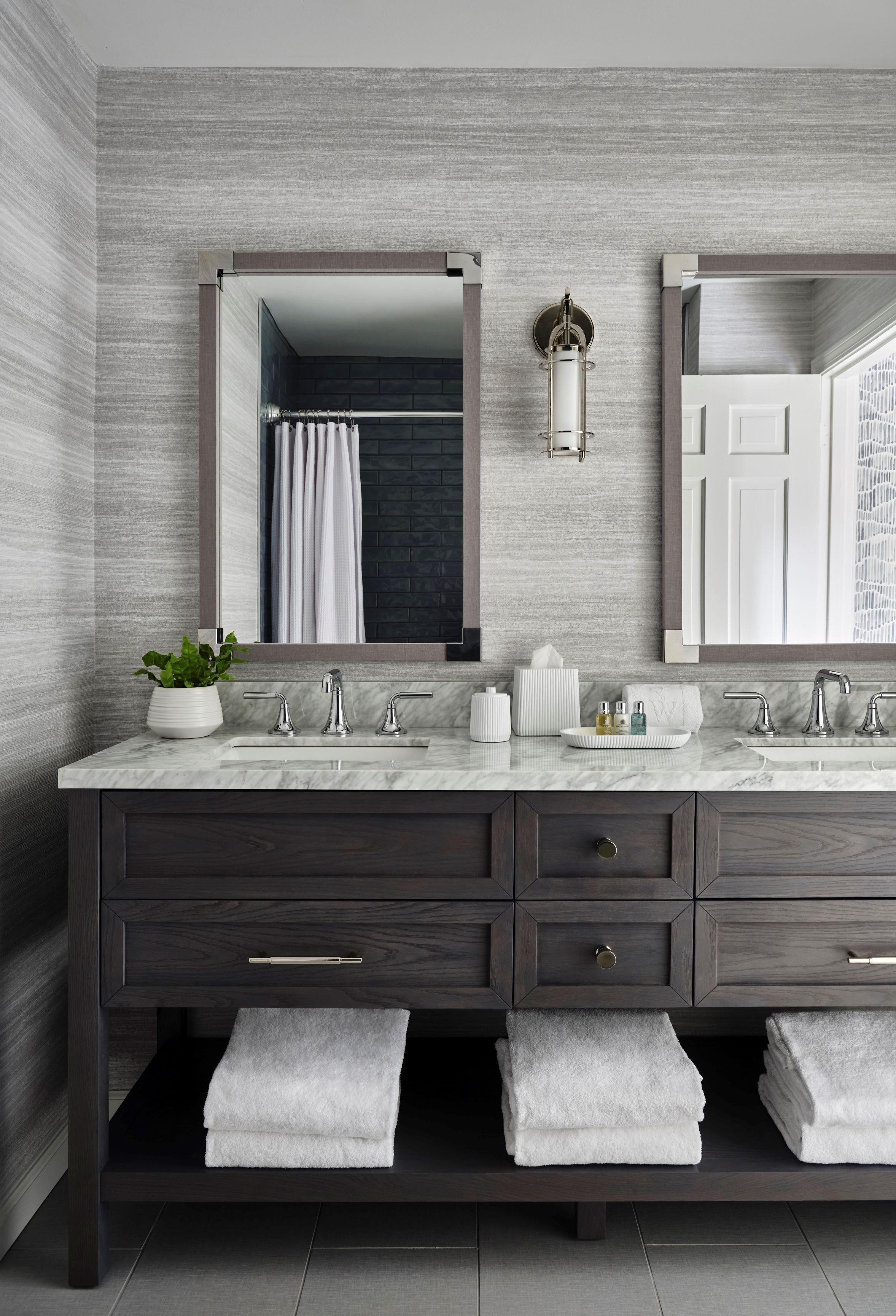 Une salle de bain moderne avec un meuble-lavabo en marbre, deux vasques et un grand miroir.