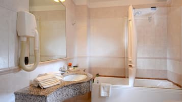 A bathroom with a granite countertop sink, a mirror, a towel rack, a shower, and a bathtub.