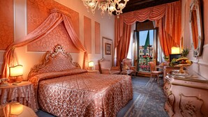 A luxurious bedroom with a large bed, ornate chandelier, and classic decor. - Hotel Rialto (Venice)