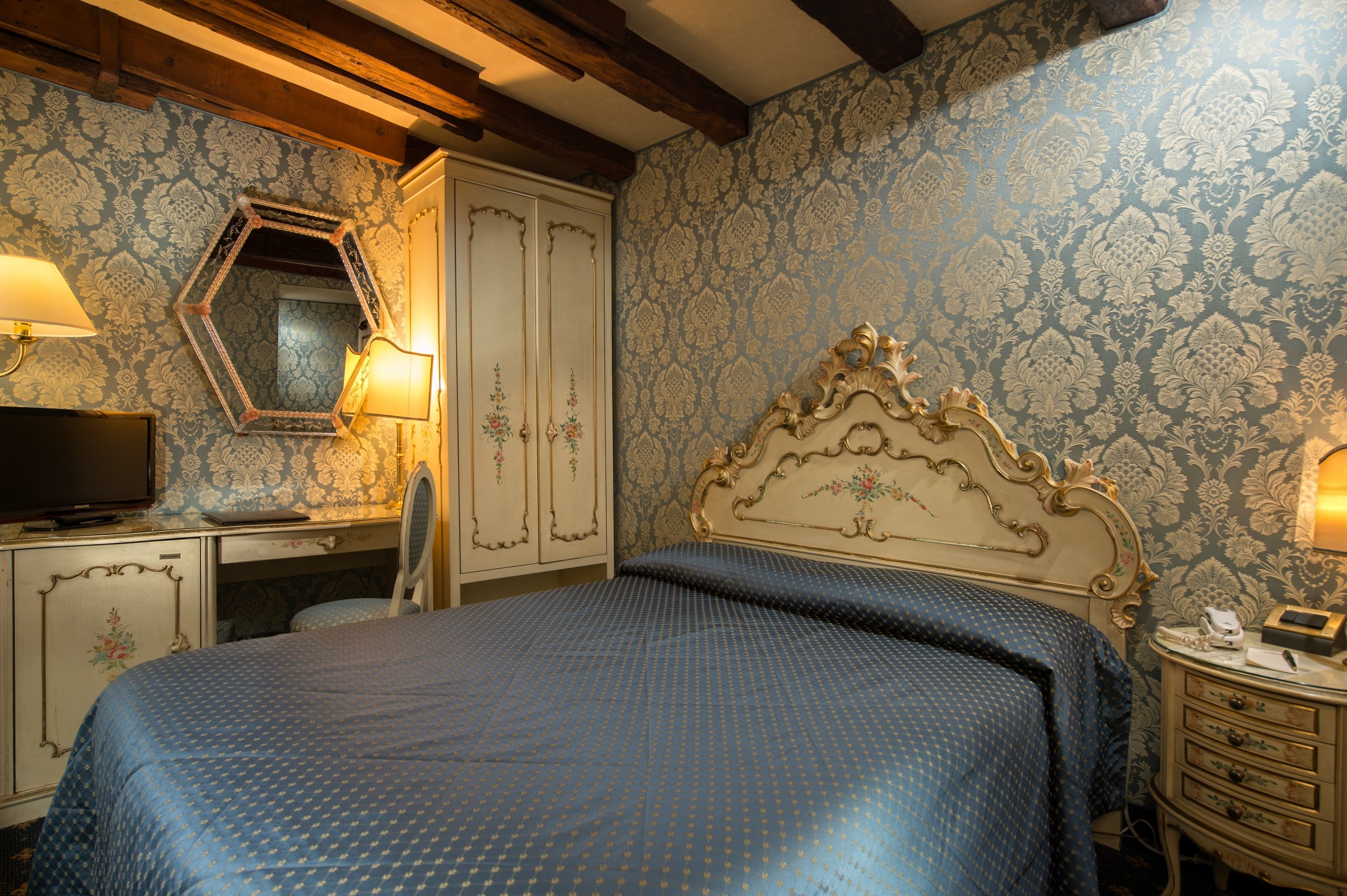 Un dormitorio con cama, cómoda, tocador y espejo.