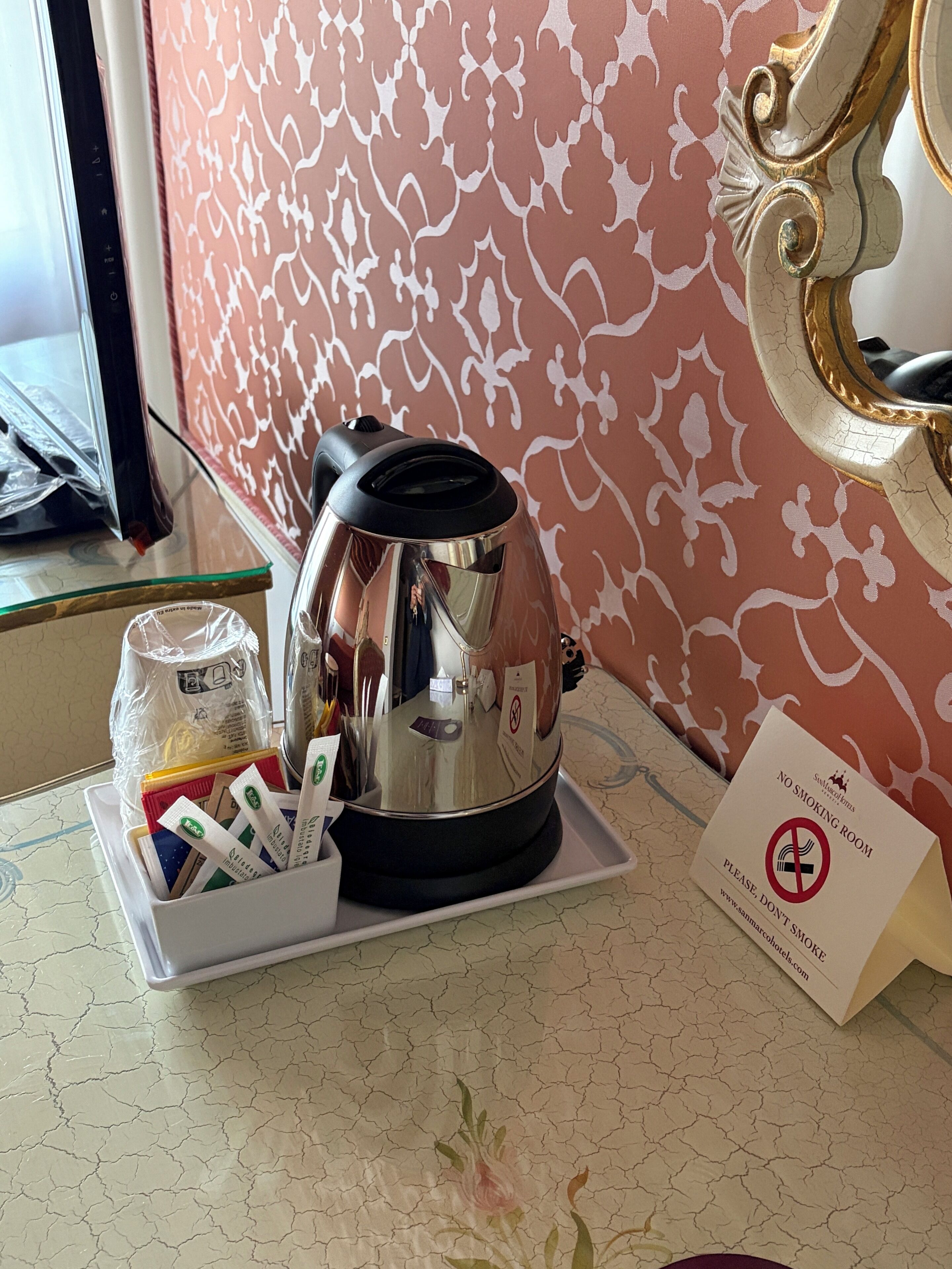 A room with a coffee maker, a tray with utensils, and a 'No Smoking' sign.