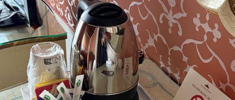 A room with a coffee maker, a tray with utensils, and a 'No Smoking' sign.