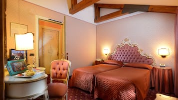 Una camera d'albergo con un letto grande, una sedia, un tavolino e una lampada.