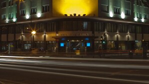 Een hotel met een grote, verlichte muurschildering op de gevel, meerdere verdiepingen en een opvallend bord bovenop.