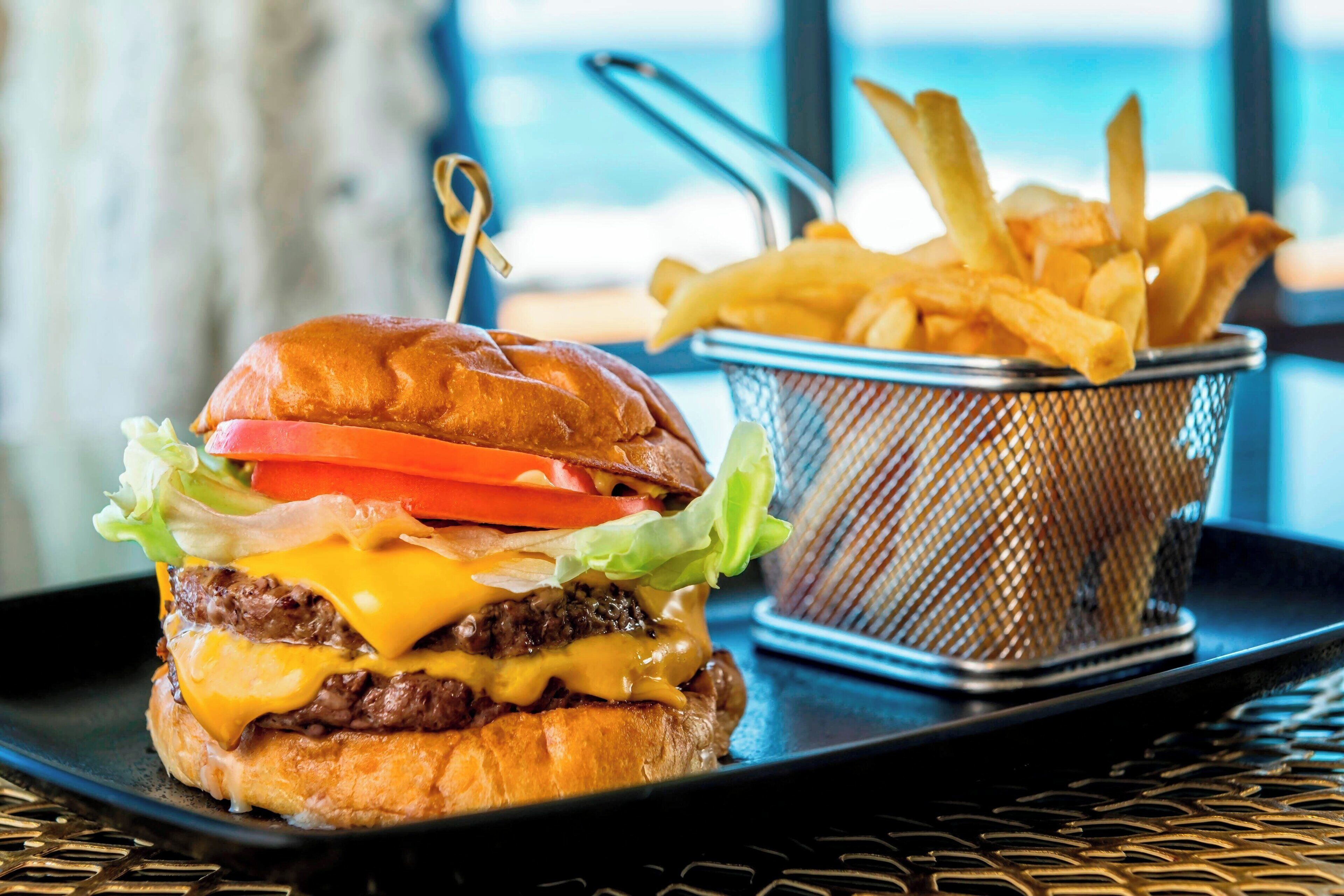 Un hamburger accompagné d’une portion de frites, le tout servi sur un plateau.