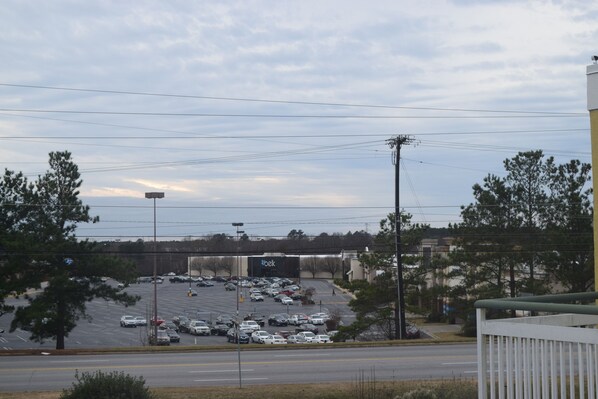 A parking lot with multiple cars and a large billboard in the background. - Quality Inn Rocky Mount near Event Center (Rocky Mount)