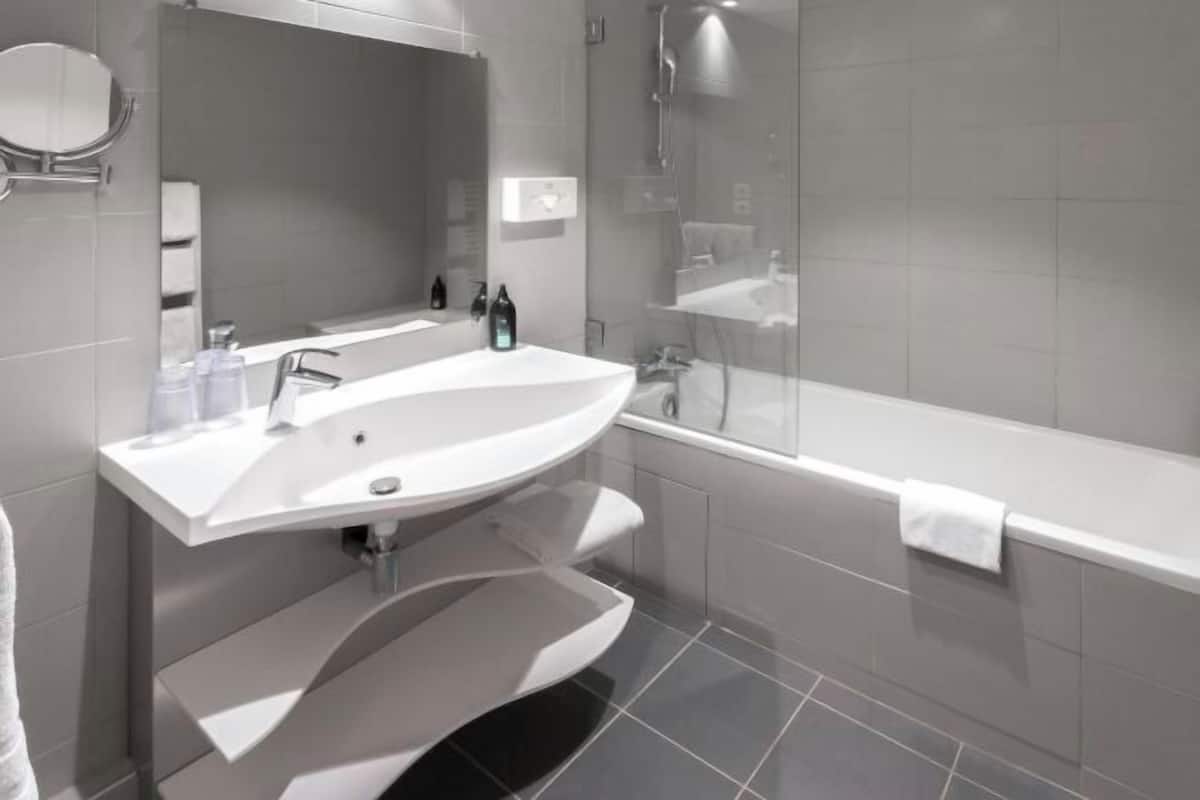 Badkamer | Een bad/douchecombinatie, milieuvriendelijk toiletgerief