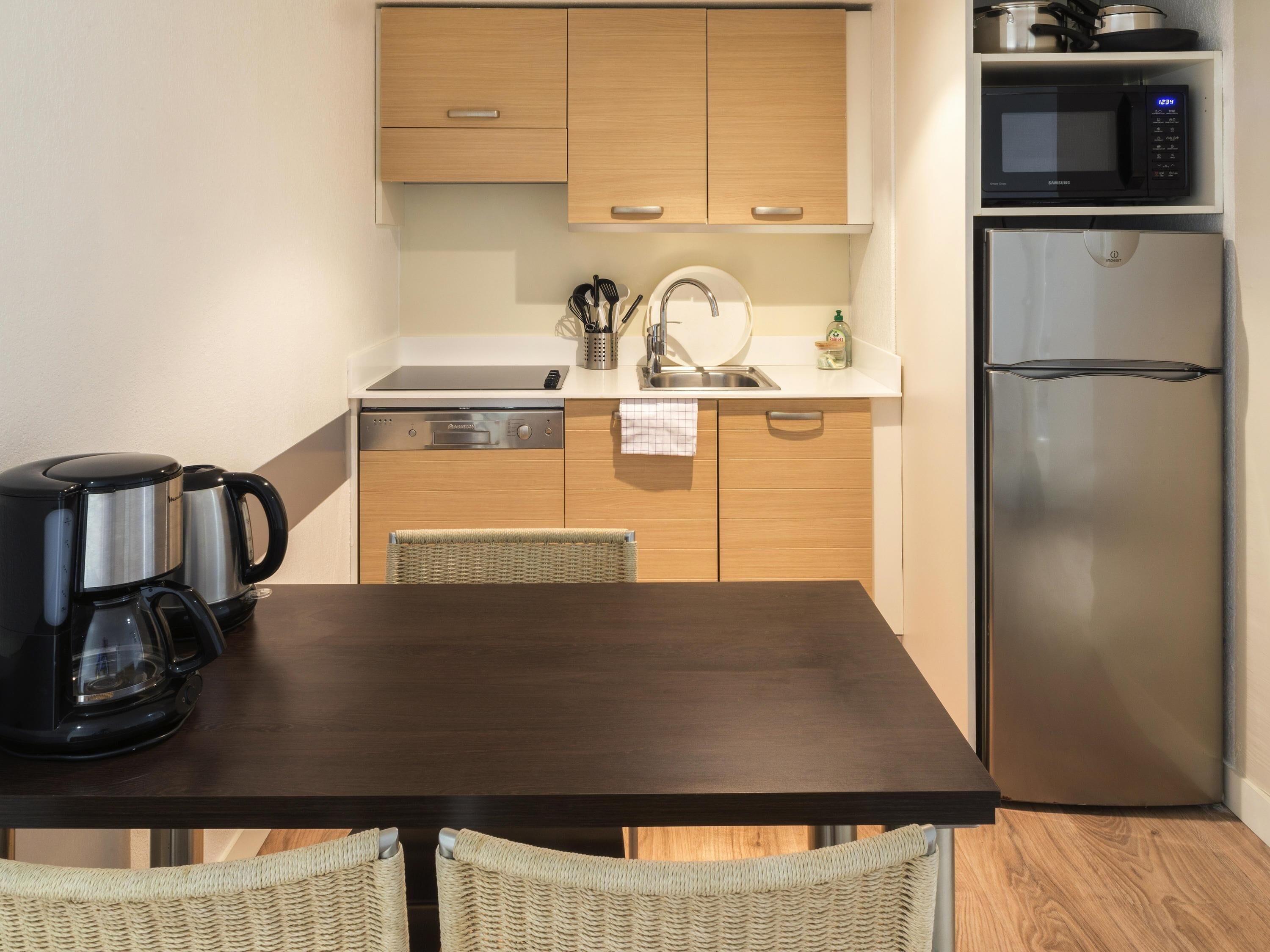Una cocina compacta equipada con microondas, refrigerador y lavavajillas.