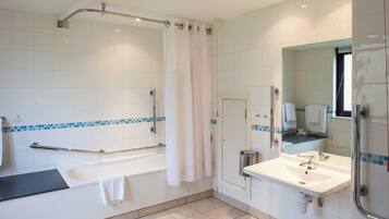 Une salle de bain moderne équipée d’une baignoire, d’une douche, d’un lavabo et d’un miroir.