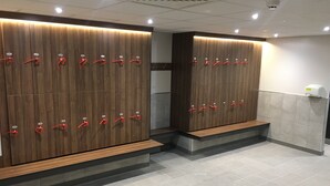 Un baño con taquillas de madera y un secador de manos.