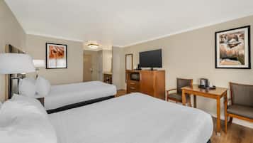 A hotel room with a large bed, a desk, a chair, a television, and artwork on the walls.