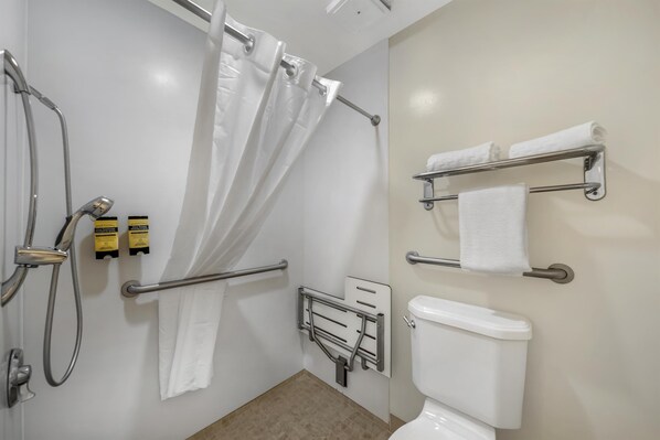 A bathroom with a shower, toilet, and grab bars. - Best Western Plus Northwoods Inn (Crescent City)