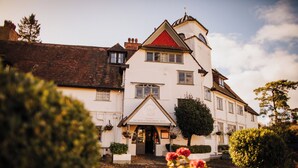Un bâtiment traditionnel avec un toit rouge, de nombreuses fenêtres et une enseigne indiquant : « The Devil's Punchbowl Hotel ».