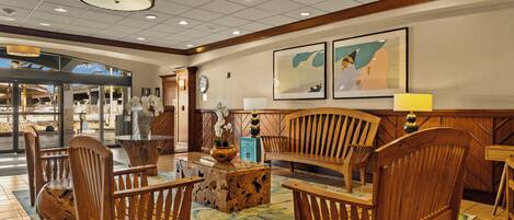 A lobby with wooden furniture, a clock, and framed artwork.