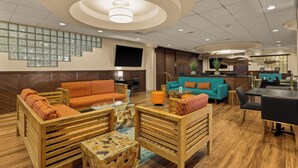A spacious lobby with wooden furniture, a teal sofa, and a modern ceiling design. - Airport Honolulu Hotel, Trademark Collection by Wyndham (Honolulu)
