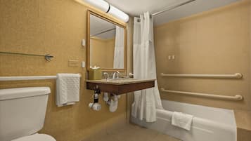 A bathroom with a toilet, sink, mirror, shower, and bathtub.