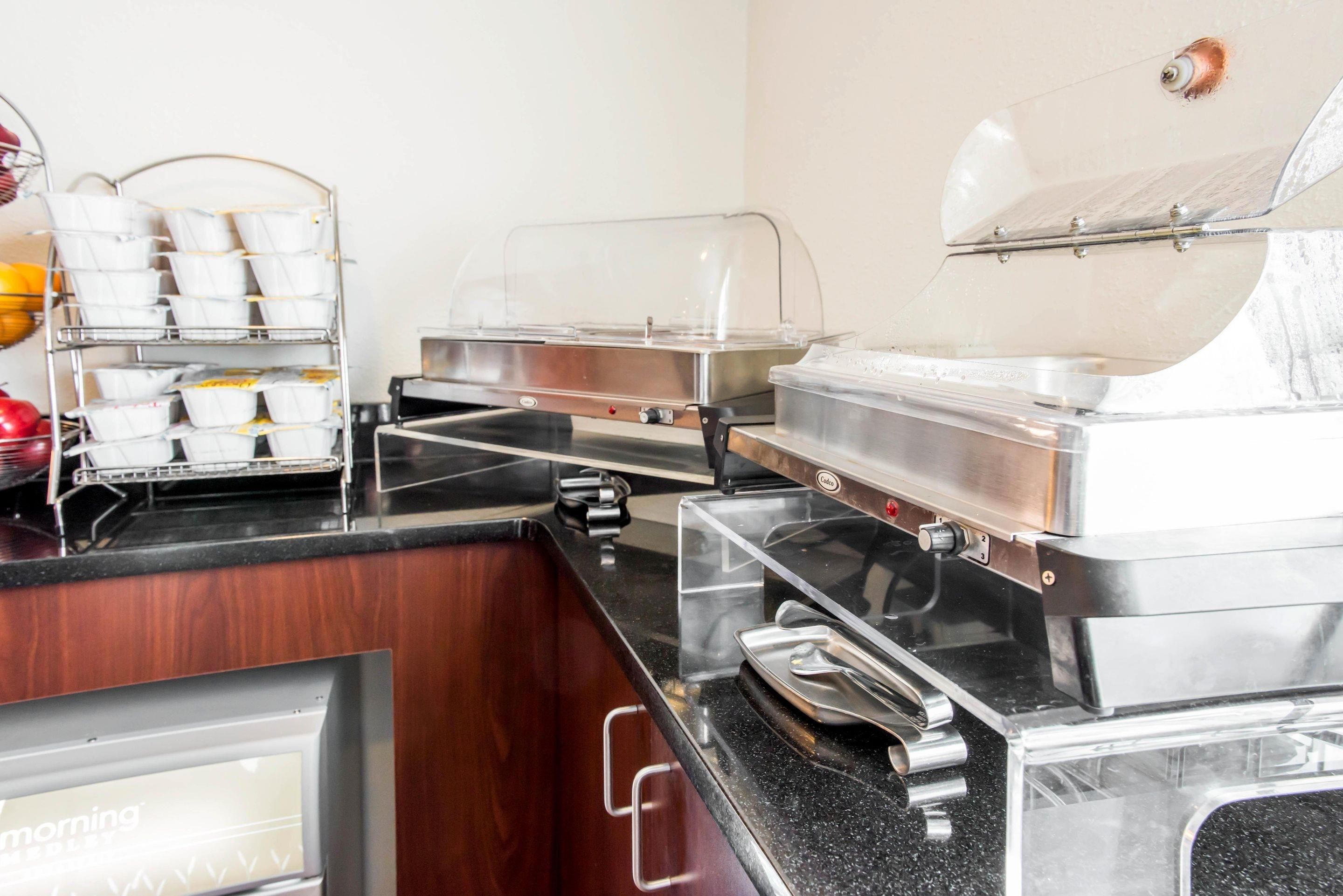 Ein Buffet mit mehreren Servierstationen, darunter eine Kaffeemaschine und eine Kühlvitrine.