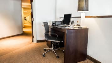 Et hotelreceptionsskrank med computer, stol og skrivebordslampe.