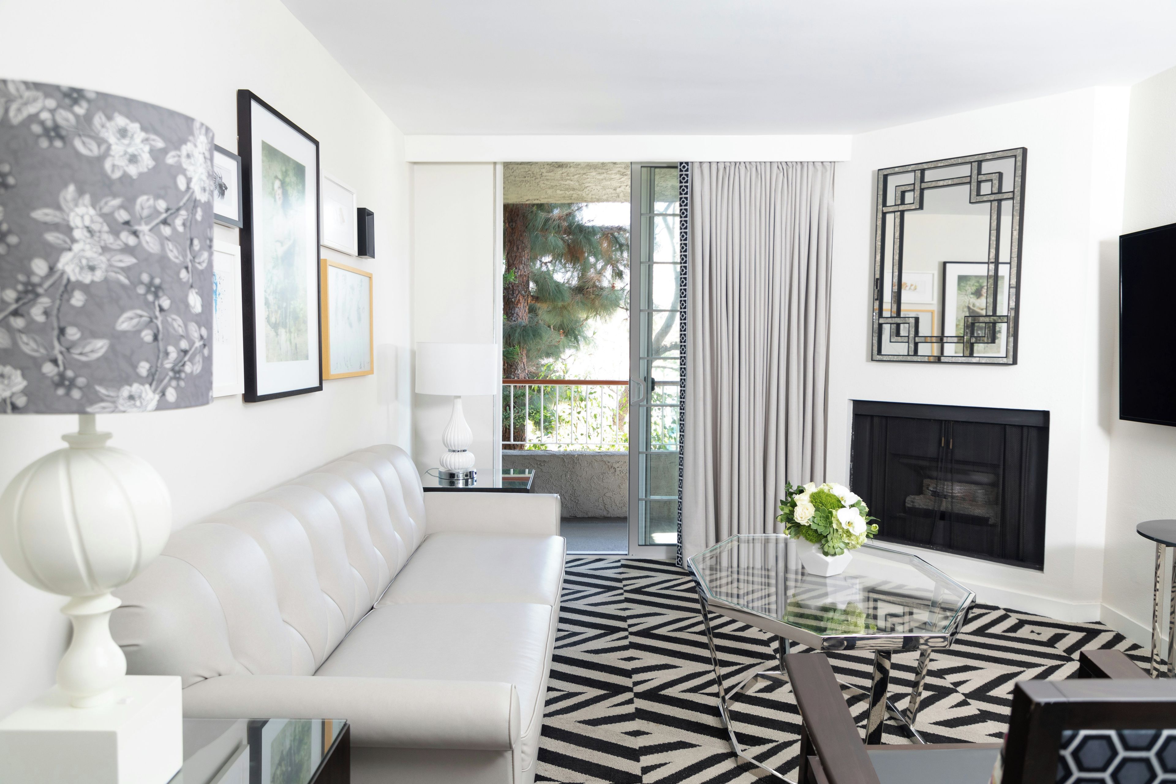 Una sala de estar moderna con un sofá blanco, una mesa de centro de cristal y una chimenea.