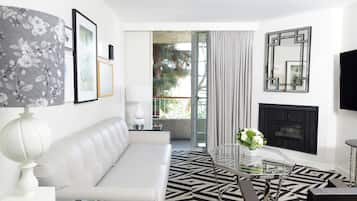 Una sala de estar moderna con un sofá blanco, una mesa de centro de cristal y una chimenea.