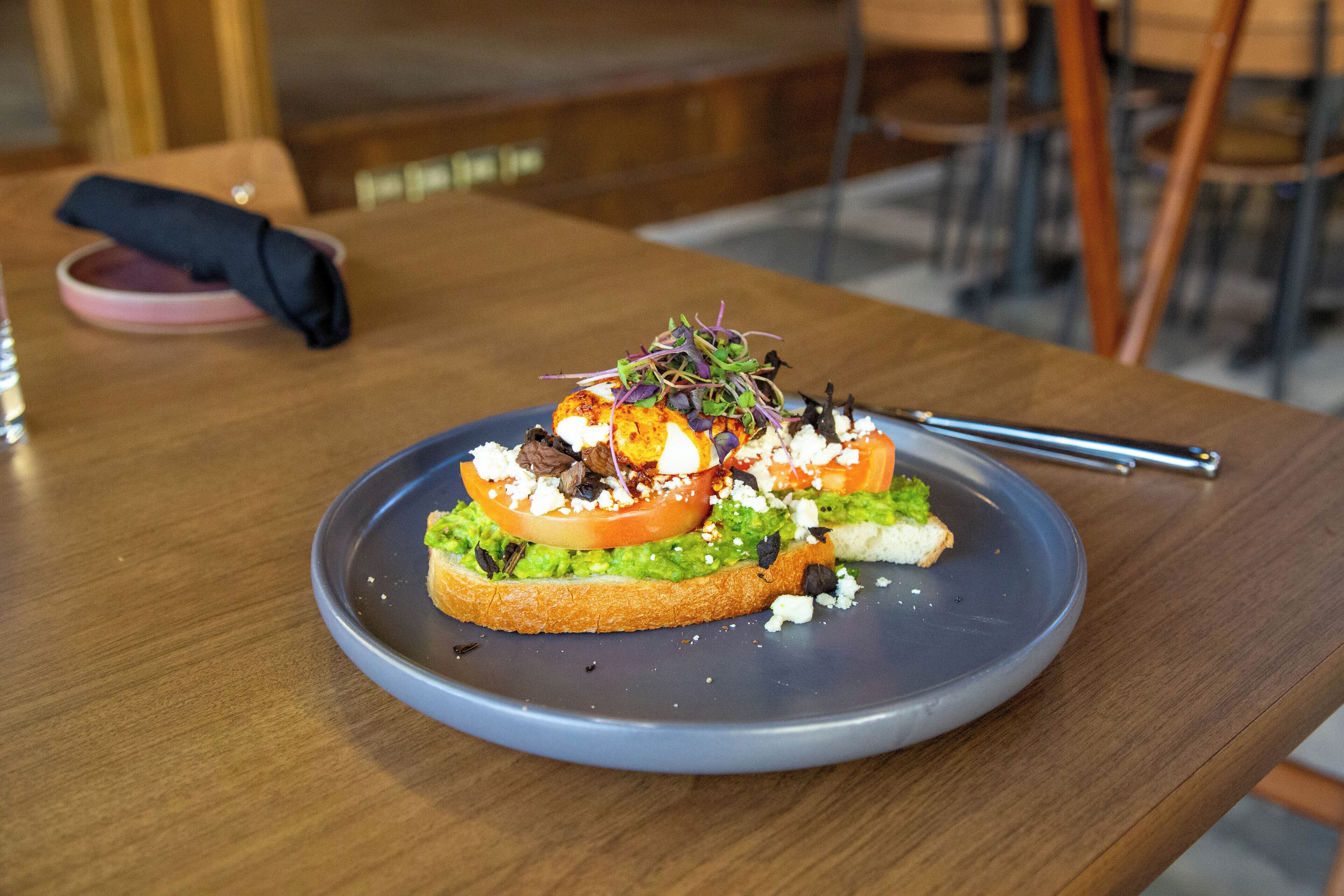 Une assiette de nourriture sur une table en bois, avec une serviette et un verre en arrière-plan.
