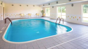 An indoor swimming pool with clear blue water, tiled floor, and several yellow chairs around the pool. - Fairfield Inn & Suites Terre Haute (Terre Haute)