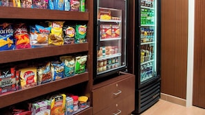 A snack and beverage vending area with multiple shelves stocked with various snacks and a refrigerator. - Fairfield Inn & Suites Terre Haute (Terre Haute)