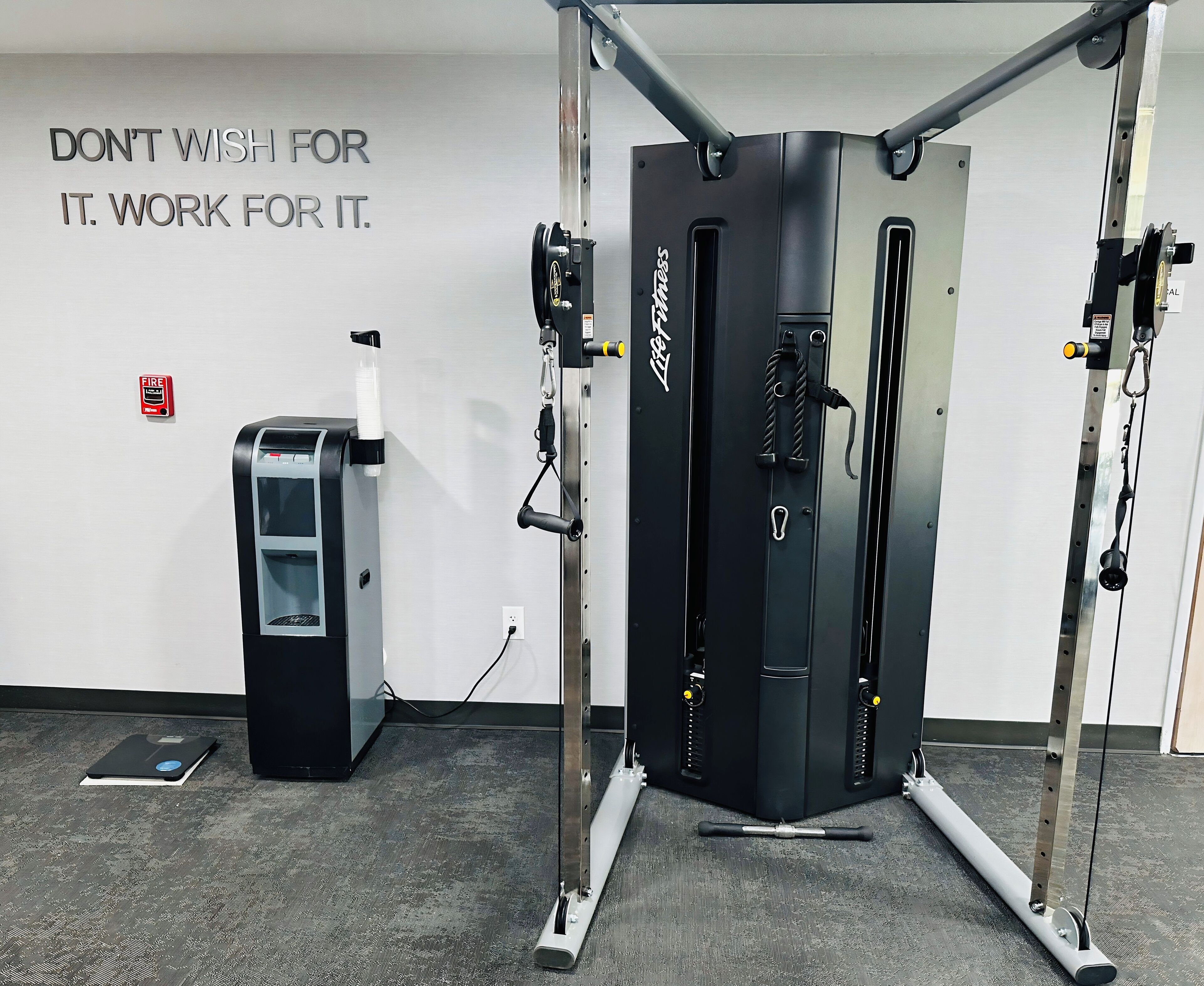 Une salle de sport équipée d’une barre de traction et d’une balance.
