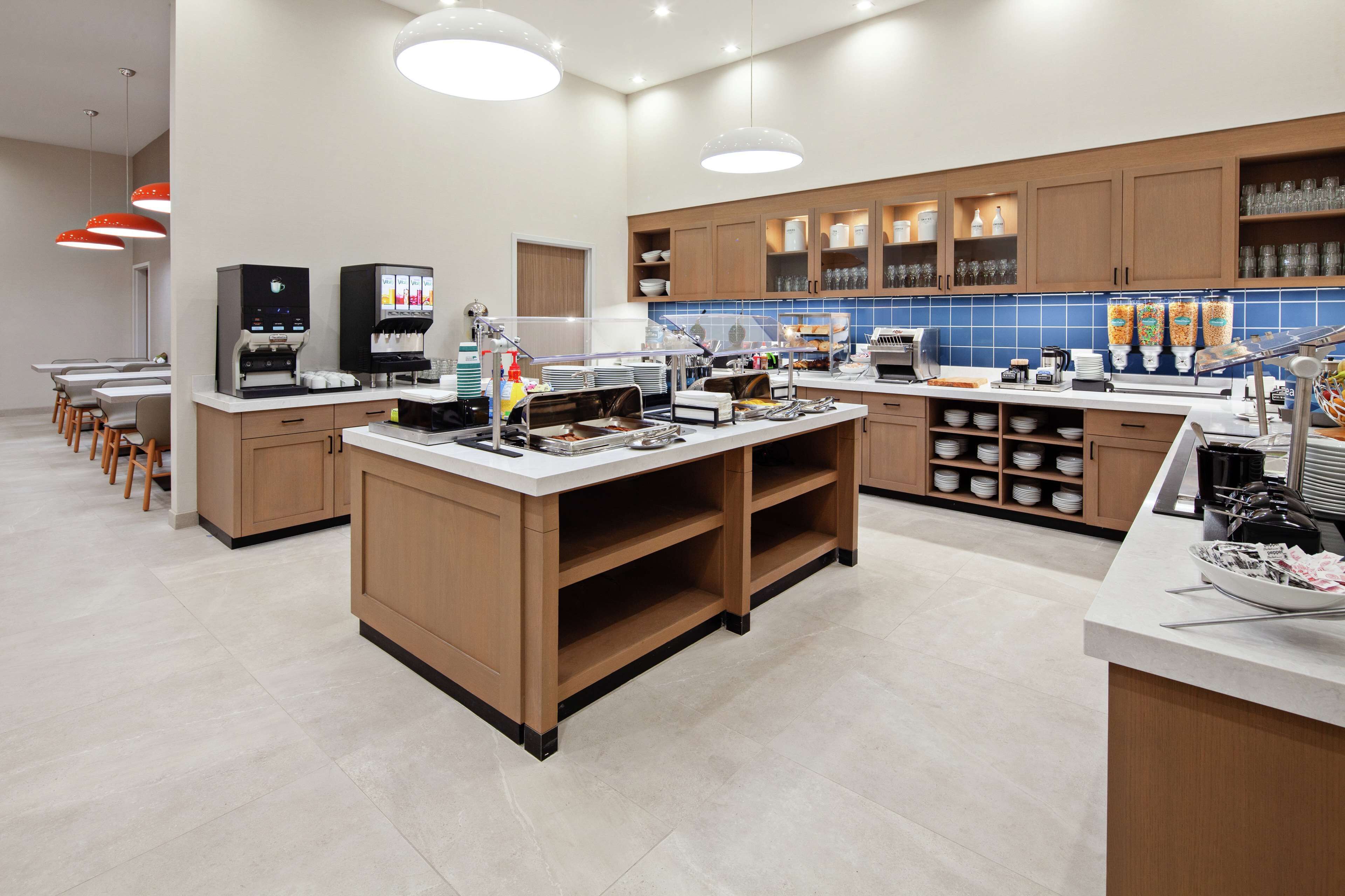 A modern kitchen with a central island, built-in appliances, and a variety of storage cabinets.
