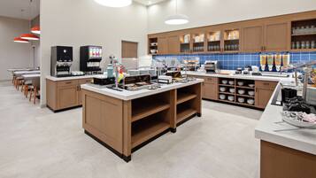 A modern kitchen with a central island, built-in appliances, and a variety of storage cabinets.