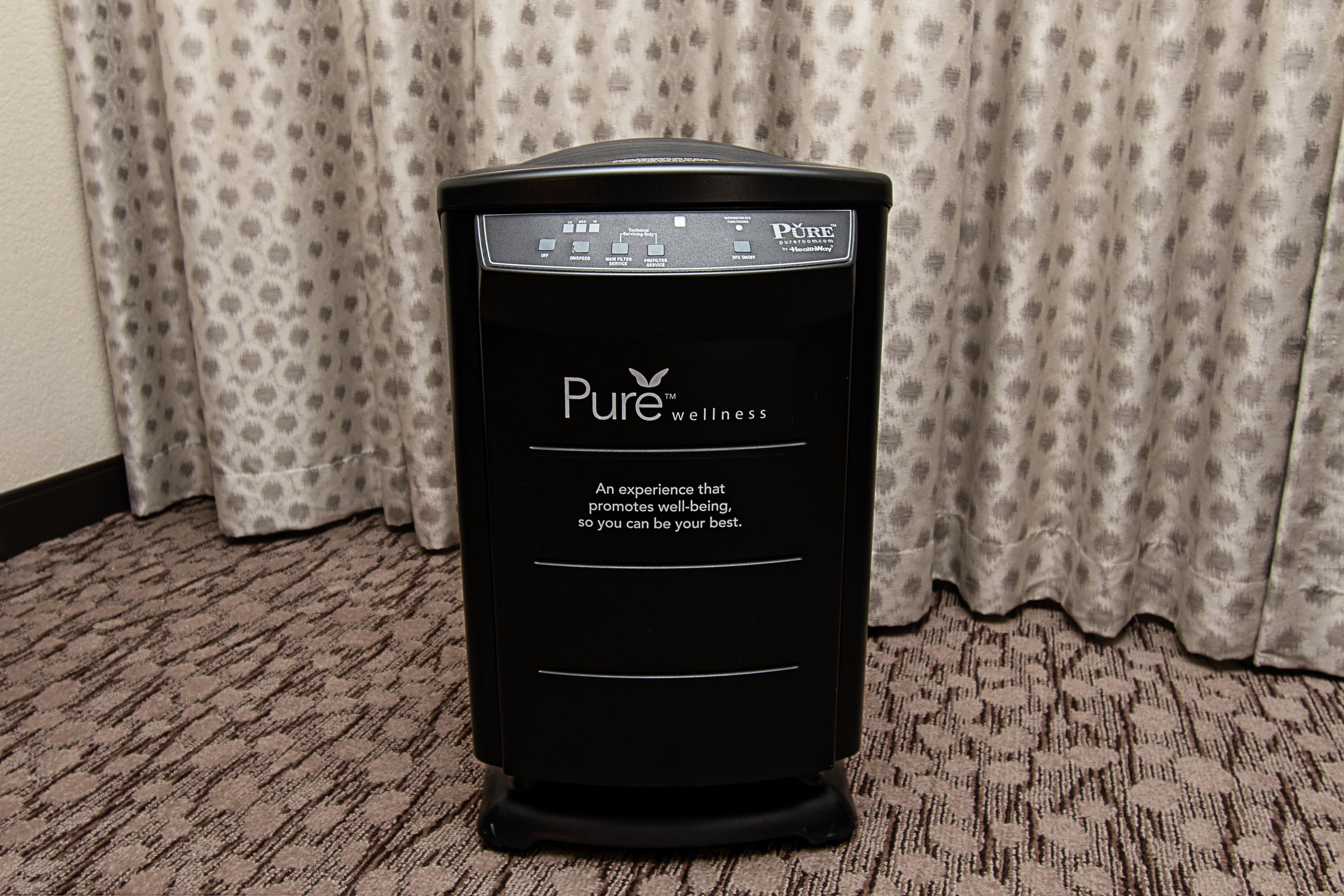 A black air purifier with the brand 'Pure' and a slogan on its side.