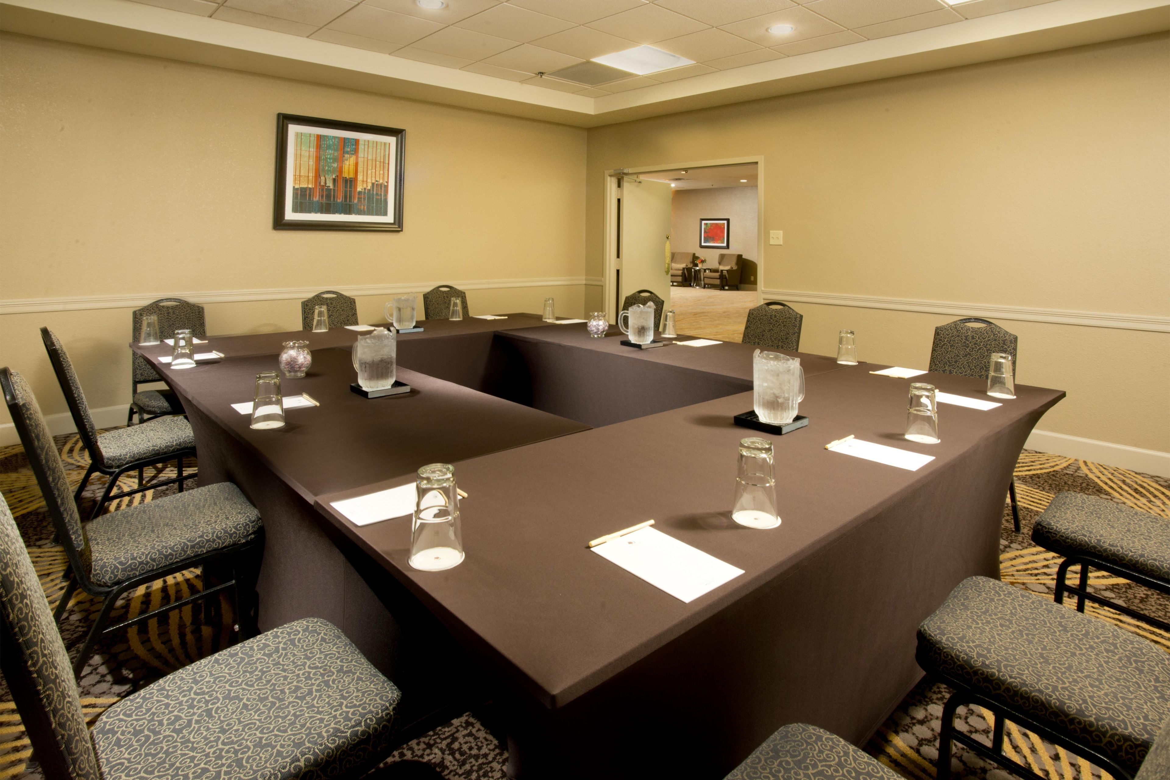 A conference room with a long table, chairs, and water pitchers.