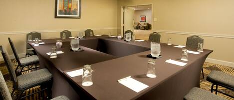 A conference room with a long table, chairs, and water pitchers.