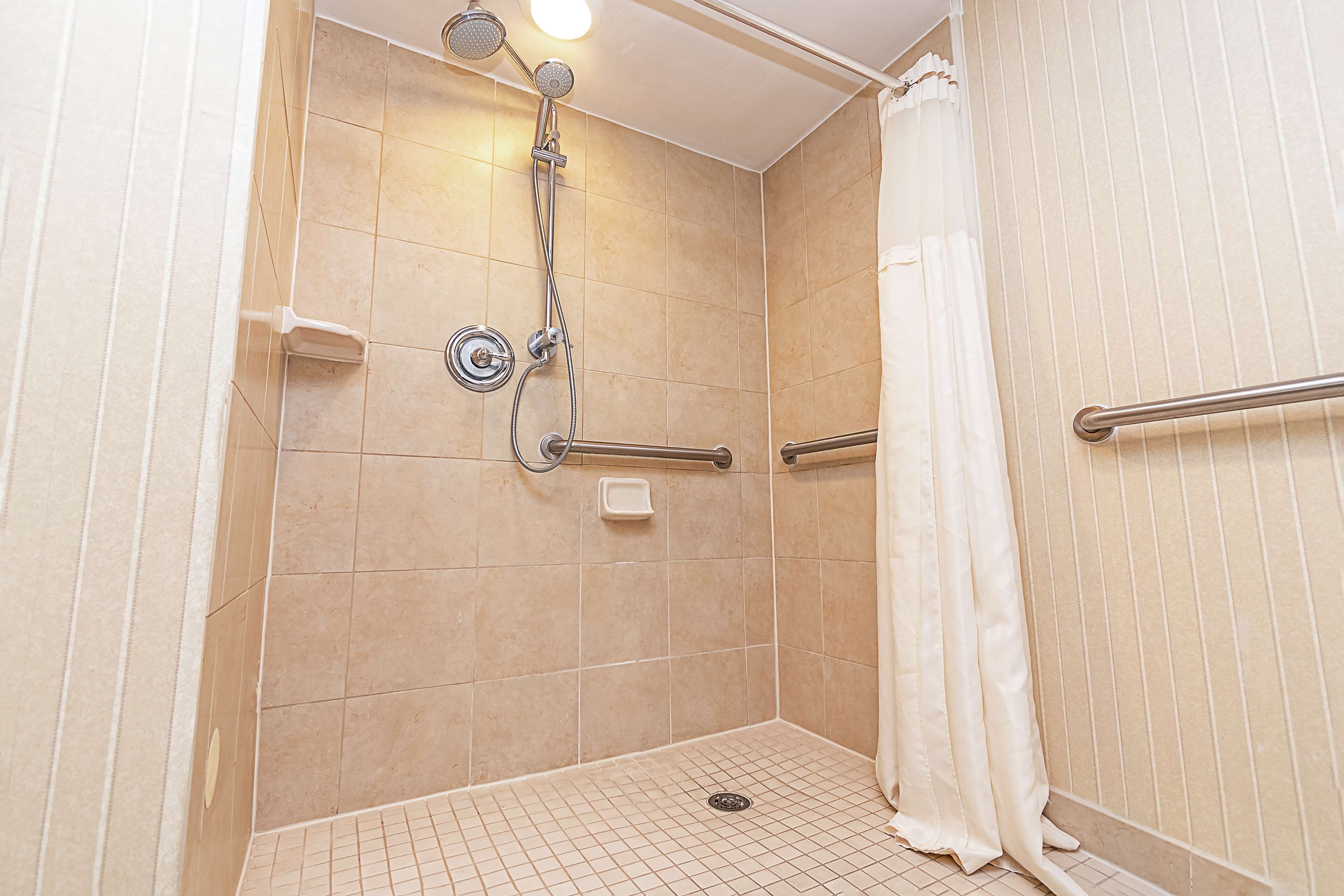 Une douche équipée d’un pommeau de douche à main, d’un autre pommeau de douche à main et d’un troisième pommeau de douche à main.