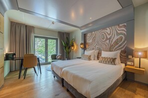 Habitación de hotel moderna con una cama grande, un escritorio y vistas al exterior.