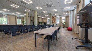 A conference room with a long table, chairs, and a red exercise ball. - Leonardo Hotel Breda City Center (Breda)