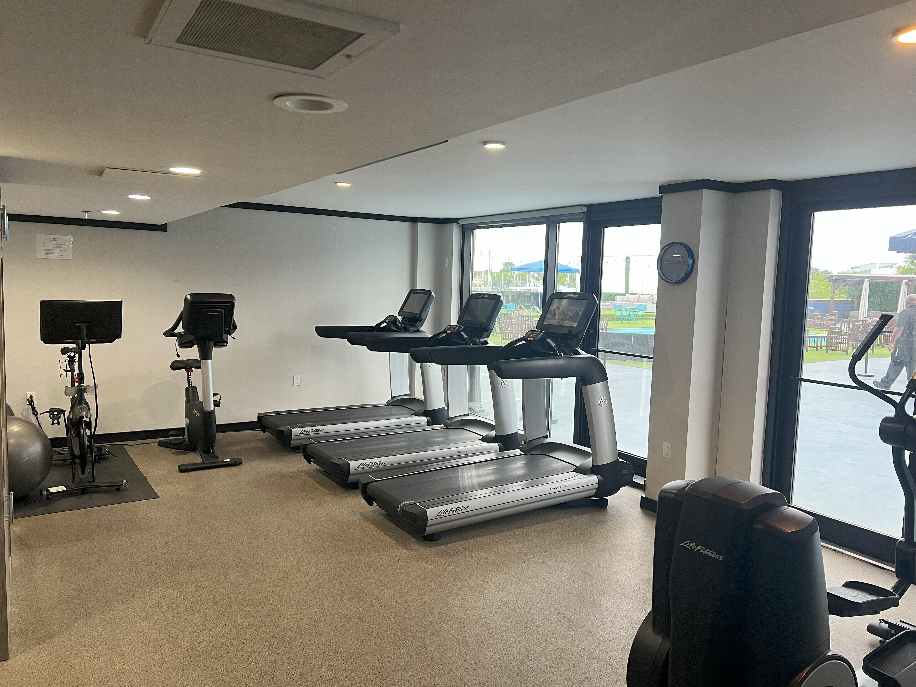 Ein Fitnessraum mit Laufbändern, Ergometer und einem Rudergerät.