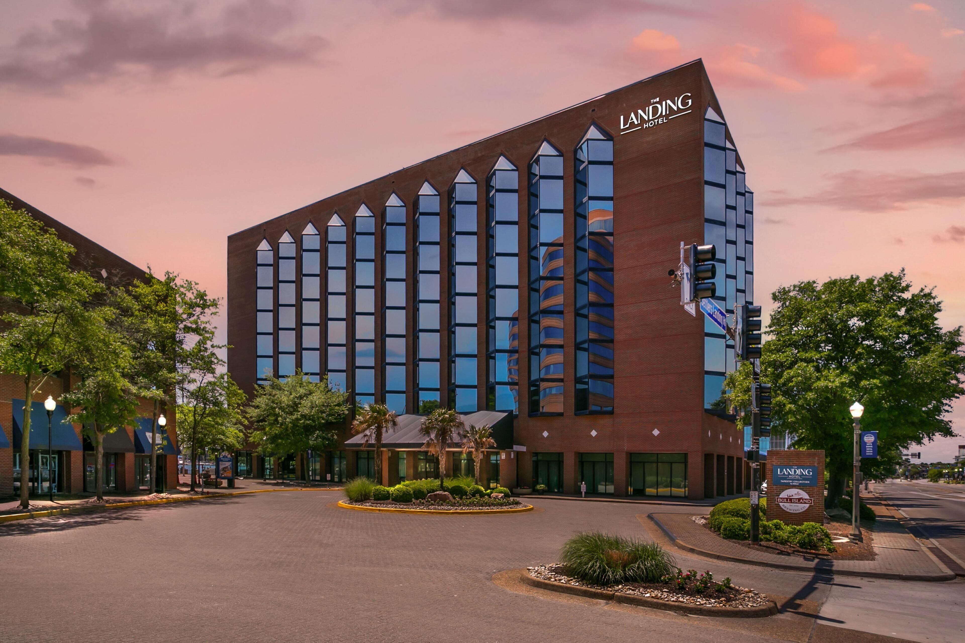 A modern hotel with a prominent 'Landing Hotel' sign, featuring a brick facade and large windows.