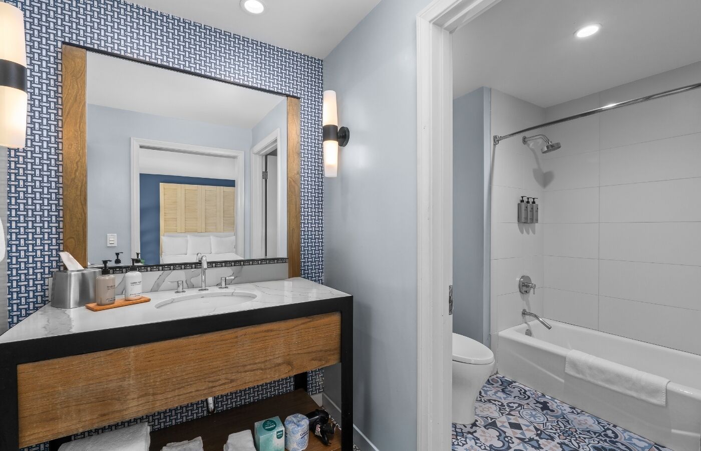A modern bathroom with a large mirror, a sink, and a shower.