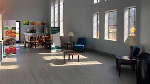 A spacious room with large windows, a dining area with chairs and tables, and a kitchenette. - Quality Inn Bennettsville (Bennettsville)