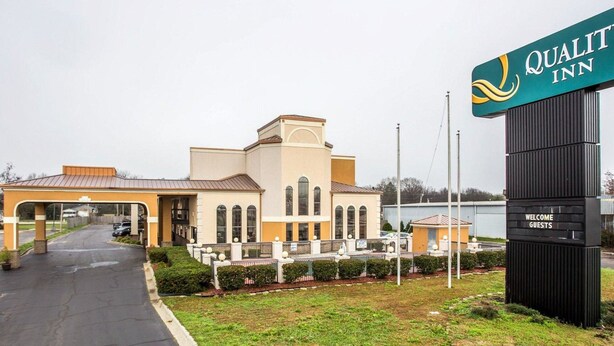 A Quality Inn hotel with a modern design, featuring a central building with arched windows and a welcoming entrance.