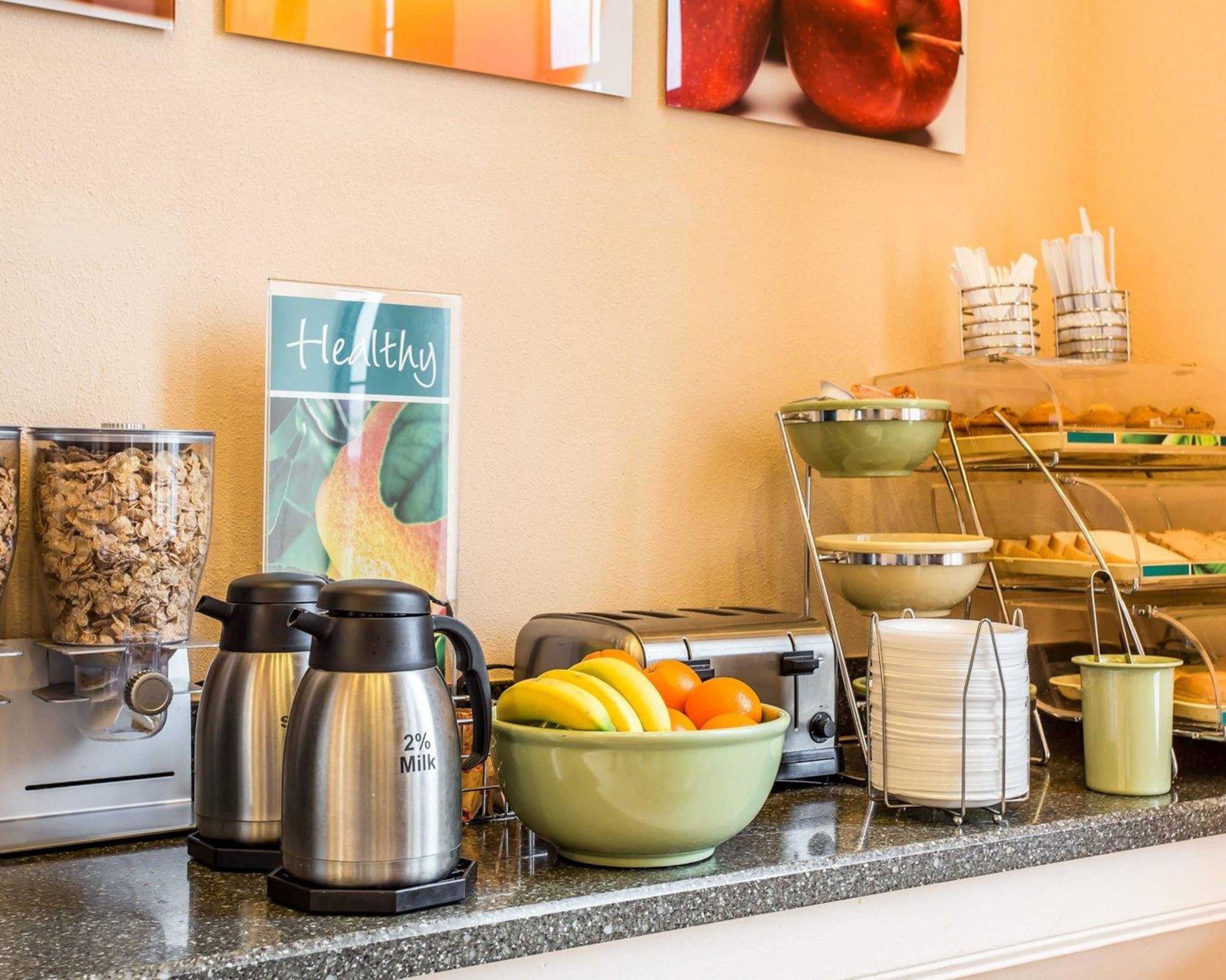 Morgenmadsbuffet med forskellige retter og et skilt med teksten "Healthy".