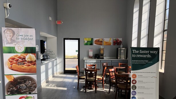 A breakfast area with a sign promoting Choice Privileges, a coffee machine, and a view of the outside. - Quality Inn Bennettsville (Bennettsville)
