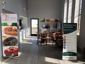 A breakfast area with a sign promoting Choice Privileges, a coffee machine, and a view of the outside. - Quality Inn Bennettsville (Bennettsville)