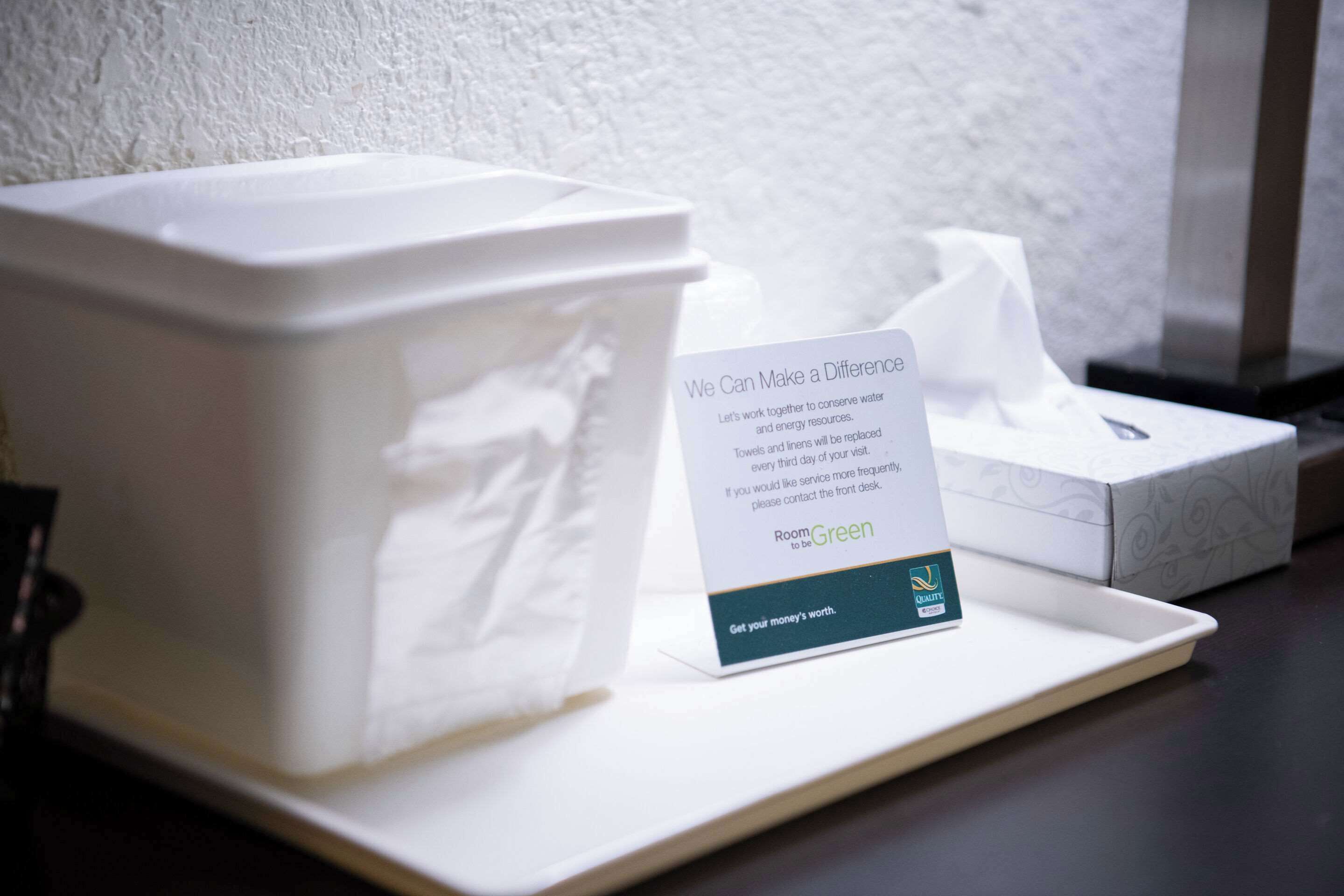 A white tissue box and a sign on a tray.