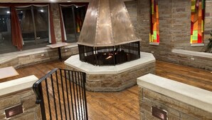 A modern interior with a stone fireplace, wooden flooring, and a staircase with metal railings. - Quality Inn Somerset (Somerset)
