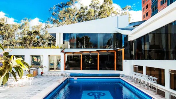 A modern pool area with a clear blue pool, a hot tub, and outdoor seating. - Oro Verde Cuenca (Cuenca)