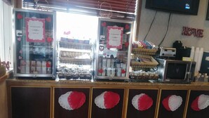 A bakery counter with display cases and a microwave. - Holiday Motel (Winnemucca)