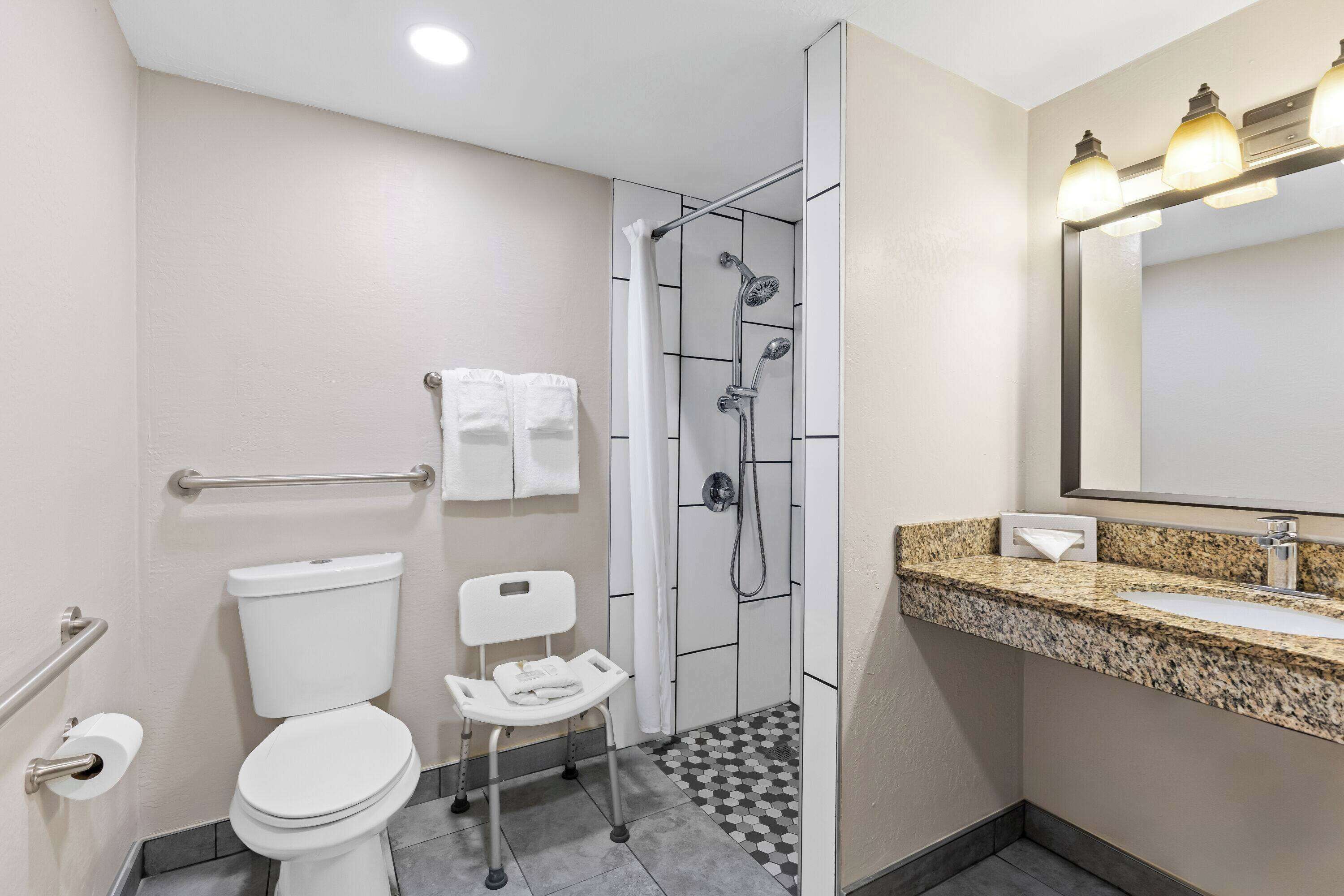 A modern bathroom with a toilet, shower, and sink.