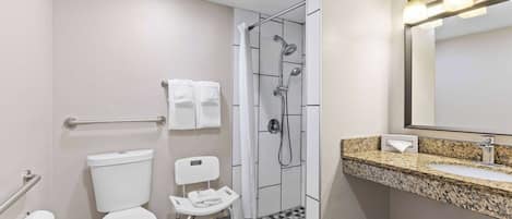 A modern bathroom with a toilet, shower, and sink.